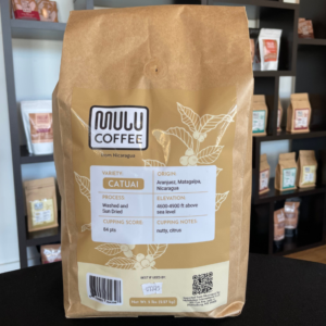 A bag of Mulü coffee, with Nicaraguan Catuai from Matagalpa, is washed and sun-dried at 4600-4900 ft. Scoring 84 points in cupping, it features nutty and citrus notes that pair beautifully on a black surface with 8 oz. Natural Cocoa Powder.